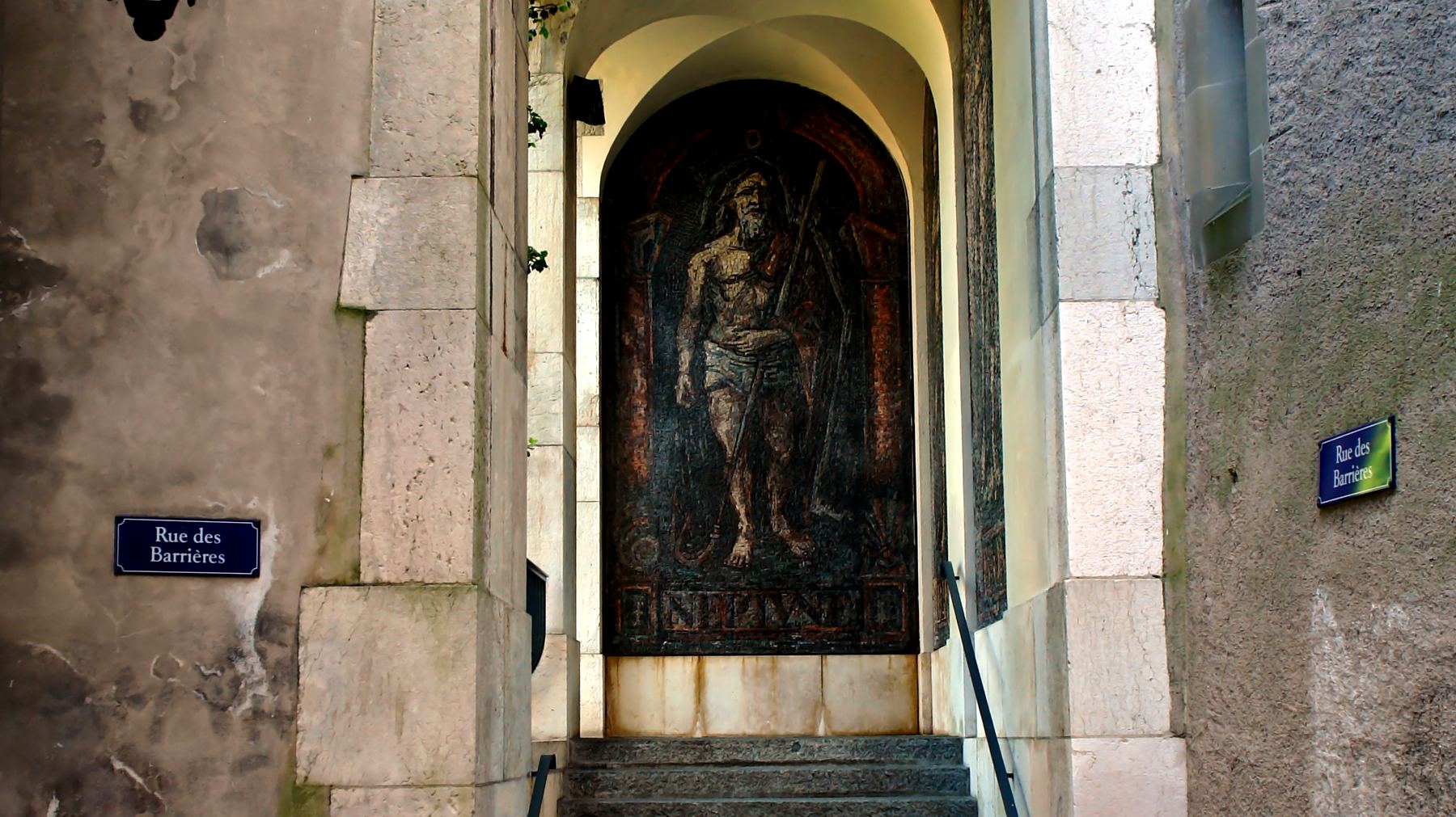 A stone doorway in Geneva's old town, with a lantern above the steps.